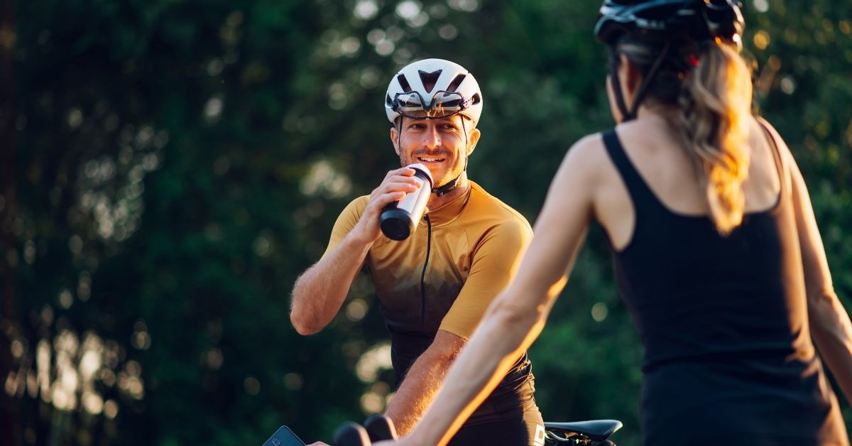 Ernährung im Radsport: Radfahrer mit Trinkflasche bei einer Pause im Training