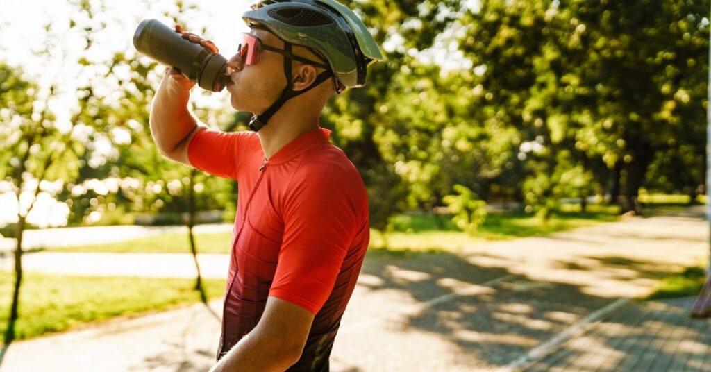 Radfahrer trinkt während einer Trainingspause – Flüssigkeit und Ernährung im Radsport